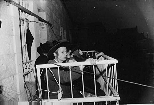 Vintage fotografija nekoliko muškaraca koji nose šešire sjedeći na balkonu.- Nov 1963